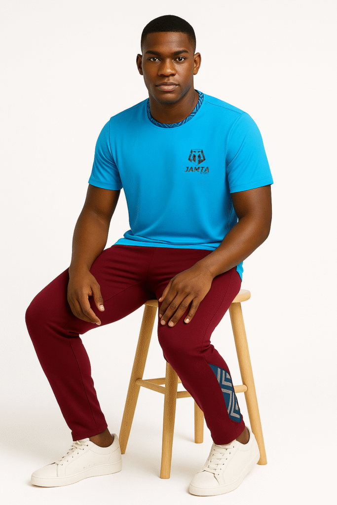 Homme assis portant la tenue Mbir de Jamta Sport : t-shirt bleu et pantalon bordeaux avec motifs bogolan.