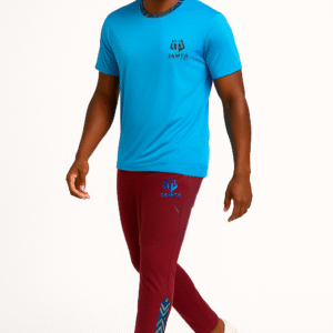 Homme portant un t-shirt bleu et un pantalon bordeaux Jamta Sport avec détails bogolan bleu. Tenue sportive moderne et identitaire.