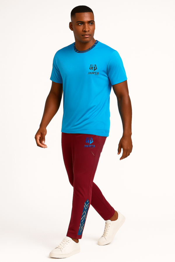 Homme portant un t-shirt bleu et un pantalon bordeaux Jamta Sport avec détails bogolan bleu. Tenue sportive moderne et identitaire.